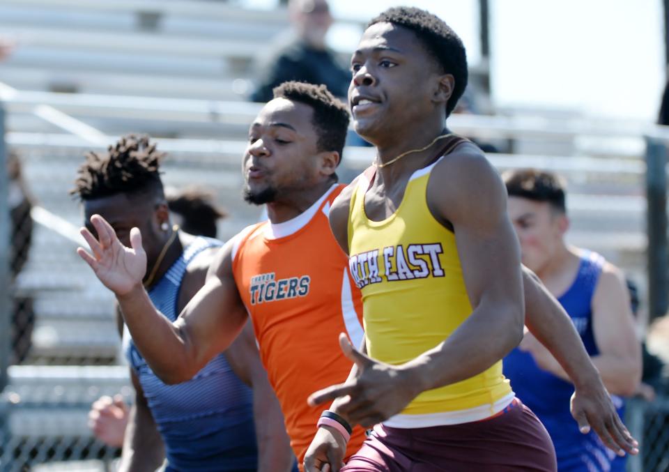 North East High School junior Jamari Curlett, top, wins the boys 100-meter dash during the North East Track & Field Invitational.