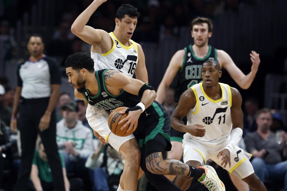 Boston Celtics' Jayson Tatum, front left, drives past Utah Jazz's Simone Fontecchio (16) during the first half of an NBA basketball game, Friday, March 31, 2023, in Boston. (AP Photo/Michael Dwyer)