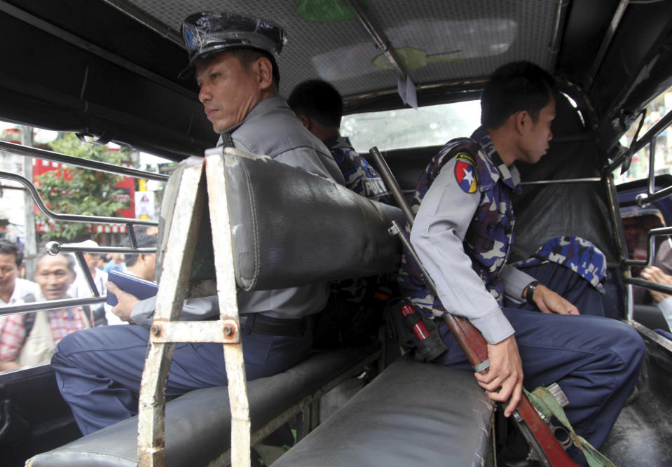 Myanmar policemen sit in their vehicle as they provide security after a bomb squad found a suspicious looking packet in downtown Yangon, Myanmar, Tuesday, Oct. 15, 2013. Police urged vigilance after several small bombs exploded in and around Myanmar's largest city of Yangon in recent days. No one claimed responsibility for the boasts and it was not immediately clear if they were related. (AP Photo/Khin Maung Win)