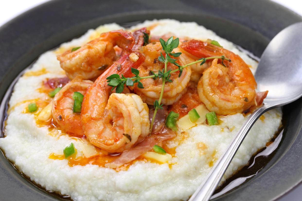 Shrimp and Grits on black plate with large spoon