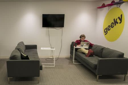 A BuzzFeed employee works on a couch at the company's headquarters in the Midtown Manhattan offices in New York in this January 9, 2014 file photo. REUTERS/Brendan McDermid/Files