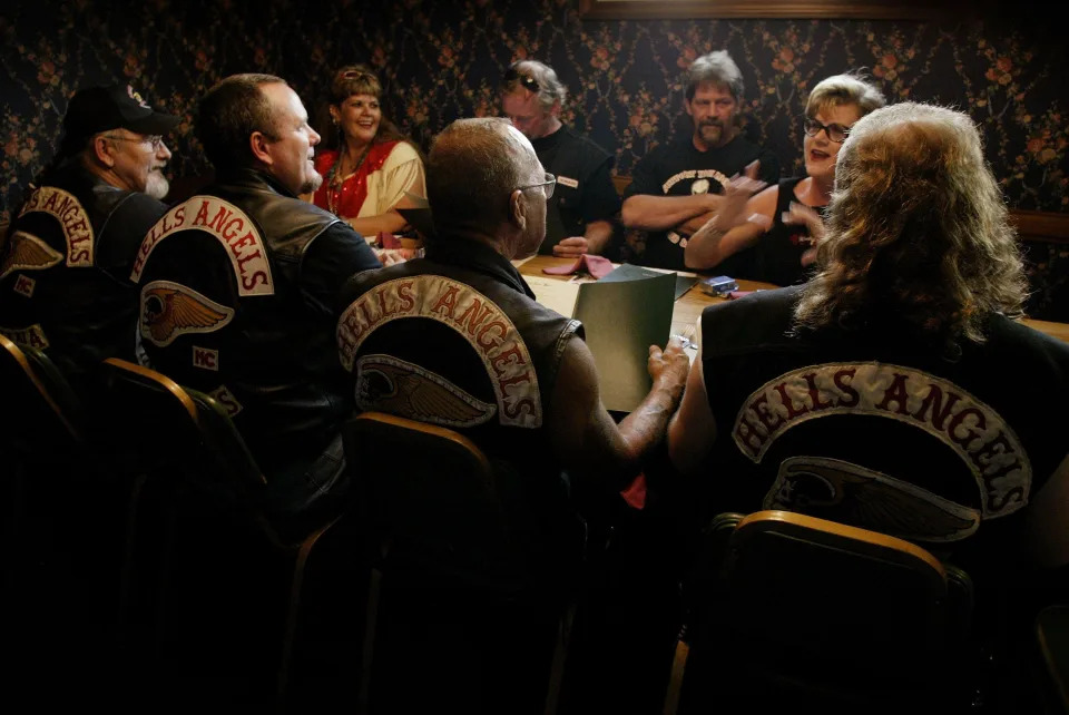 Members of the Hells Angels motorcycle club, with wives and friends, order dinner at a restaurant August 23, 2003 in Quincy, Illinois. The motorcycle club was in Quincy for a book signing event and party honoring Sonny Barger (2nd-R/back to camera), founder of the Oakland, California charter of the Hells Angels.