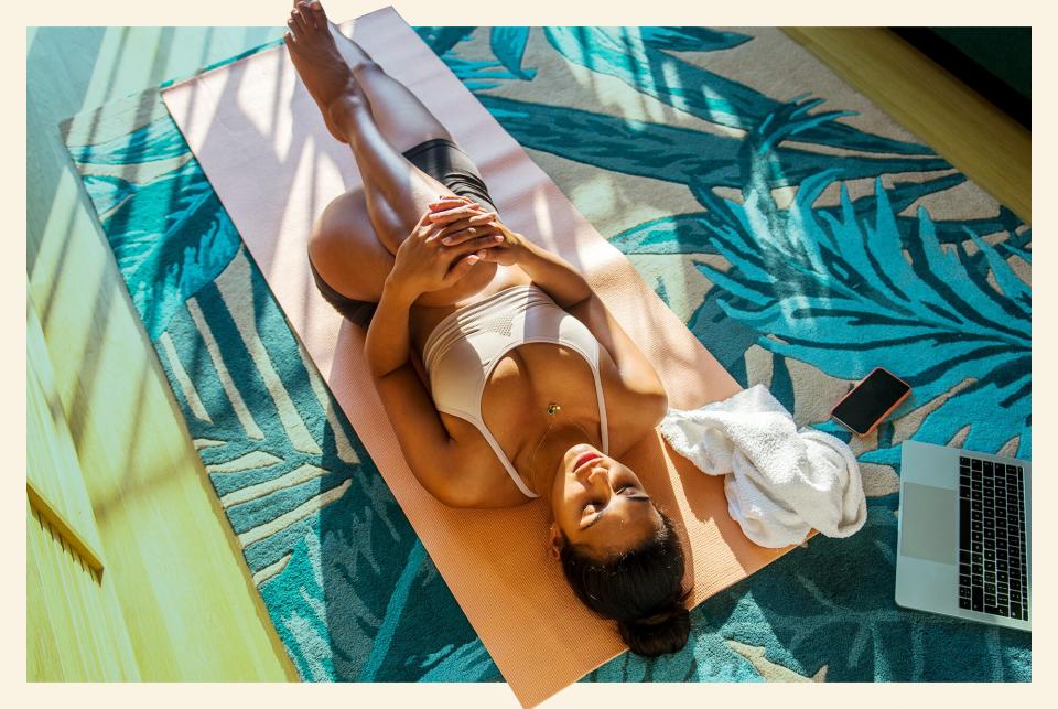 woman stretching on living room floor