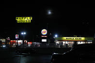 Un Waffle House, Burger King y Taco Bell con los carteles iluminados de noche junto a una carretera en Burlington, Carolina del Norte, el lunes 9 de marzo de 2020. (AP Foto/Jacquelyn Martin)