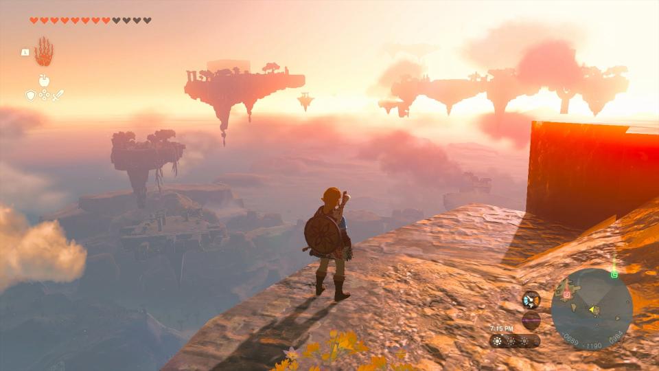 Une Capture D'Écran Du Jeu The Legend Of Zelda: Tears Of The Kingdom, Montrant Le Personnage Link Debout Au Bord D'Une Falaise Et Regardant Le Coucher Du Soleil.