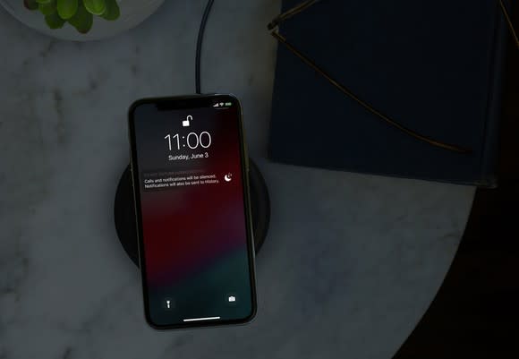 An Apple iPhone X on a wireless charging pad.