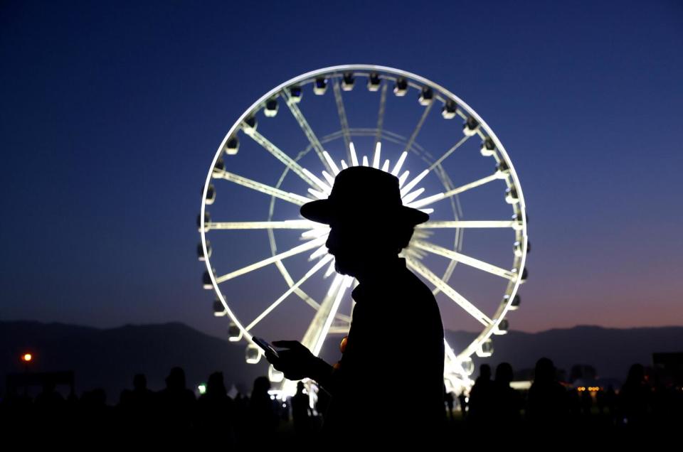 A music fan is silhouetted at dusk at Coachella.