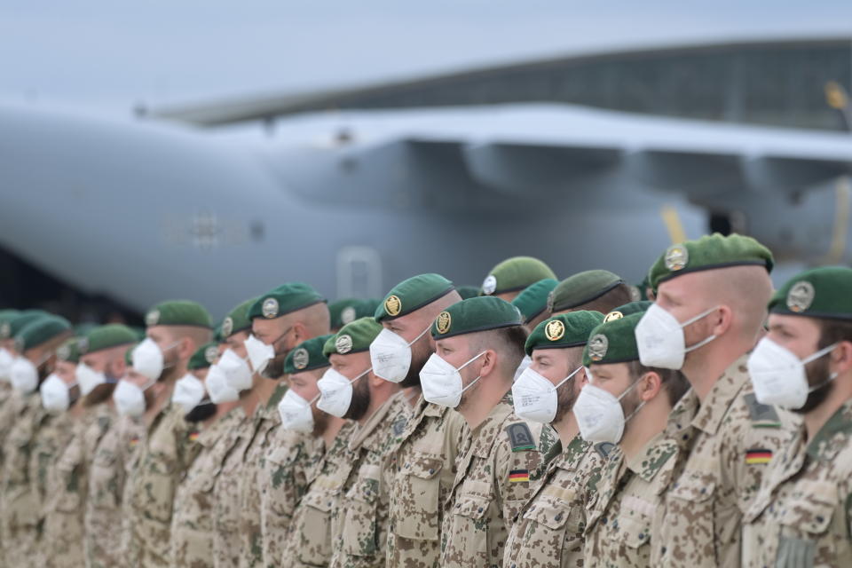 Soldiers of the German Armed Forces have lined up in front of the Airbus A400M transport aircraft of the German Air Force for the final roll call in Wunstorf, Germany, Wednesday, June 30, 2021. The last soldiers of the German Afghanistan mission have arrived at the air base in Lower Saxony. The mission had ended the previous evening after almost 20 years. The soldiers had been flown out with four military planes from the field camp in Masar-i-Sharif in the north of Afghanistan. (Hauke-Christian Dittrich/Pool via AP)