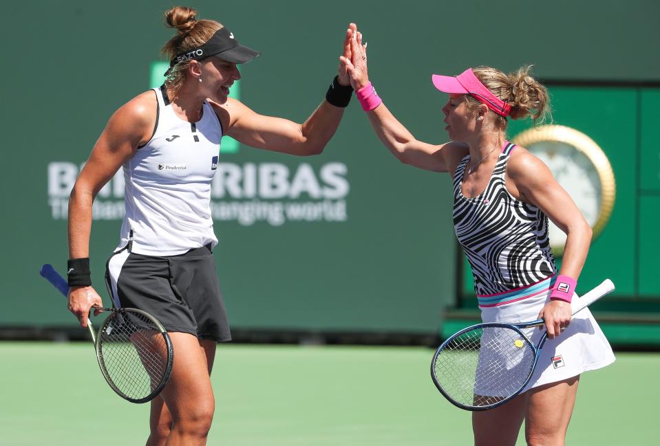 Beatriz Hadda Maia, left, and Laura Siegemund high five after winning a point in the doubles finals match during the BNP Paribas Open at the Indian Wells Tennis Garden in Indian Wells, Calif., March 18, 2023.