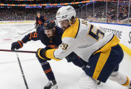 Nashville Predators' Roman Josi (59) and Edmonton Oilers' Leon Draisaitl (29) battle for the puck during third-period NHL hockey game action in Edmonton, Alberta, Thursday, Jan. 27, 2022. (Jason Franson/The Canadian Press via AP)