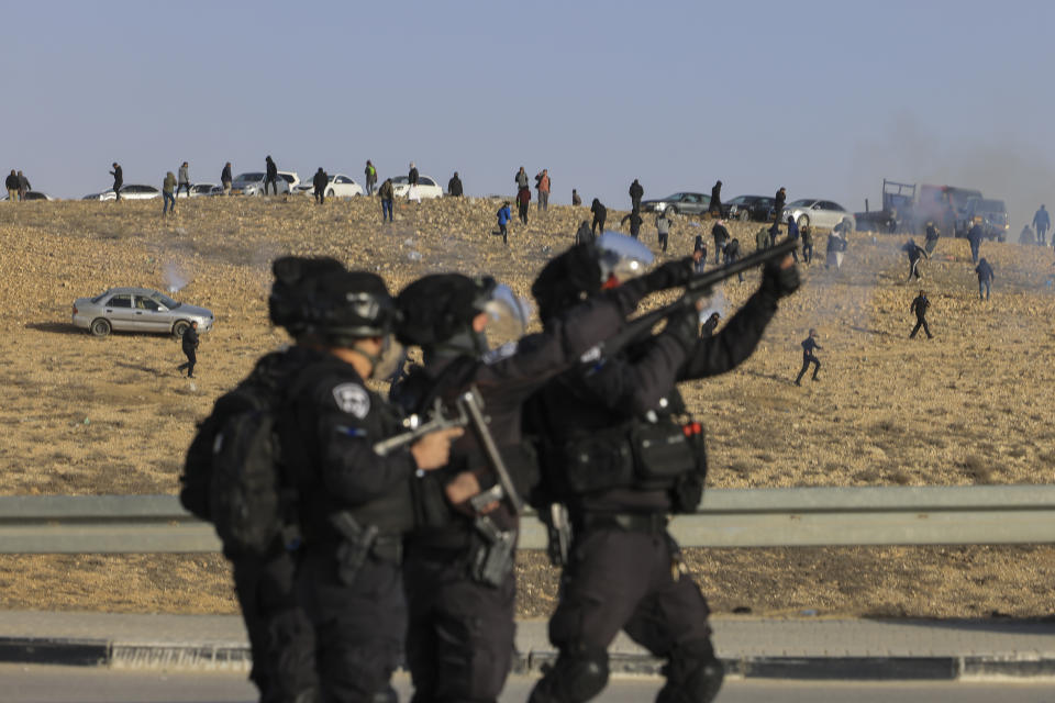 Israeli security forces fire tear gas at Bedouin protesters following a protest against an afforestation project by the Jewish National Fund in the Bedouin village of Sa'we al-Atrash in the Negev Desert, southern Israel, Thursday, Jan. 13, 2022. (AP Photo/Tsafrir Abayov)
