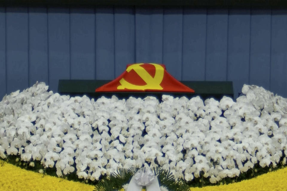 In this image taken from video footage run by China's CCTV, a Chinese Communist Party flag covers the cremated remains of late former Chinese President Jiang Zemin during a formal memorial held at the Great Hall of the People in Beijing on Tuesday, Dec. 6, 2022. (CCTV via AP)