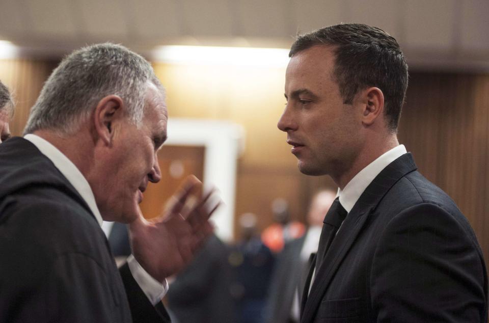 South African Olympic and Paralympic athlete Oscar Pistorius talks to his defence lawyer Barry Roux (L) during his murder trial in the North Gauteng High Court in Pretoria June 30, 2014. Pistorius is on trial for murdering his girlfriend Reeva Steenkamp at his suburban Pretoria home on Valentine's Day last year. REUTERS/Ihsaan Haffejee/Pool