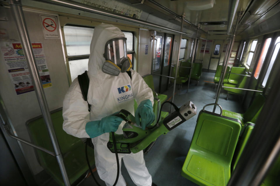 A member of a cleaning crew wearing protective mask and suit disinfects a metro car as a preventive measure against the spread of the new coronavirus in Mexico City, Wednesday, March 18, 2020. For most people COVID-19 causes mild or moderate symptoms. For others, especially the elderly and people with existing health problems, it can cause many other serious illnesses, including pneumonia. (AP Photo/Marco Ugarte)