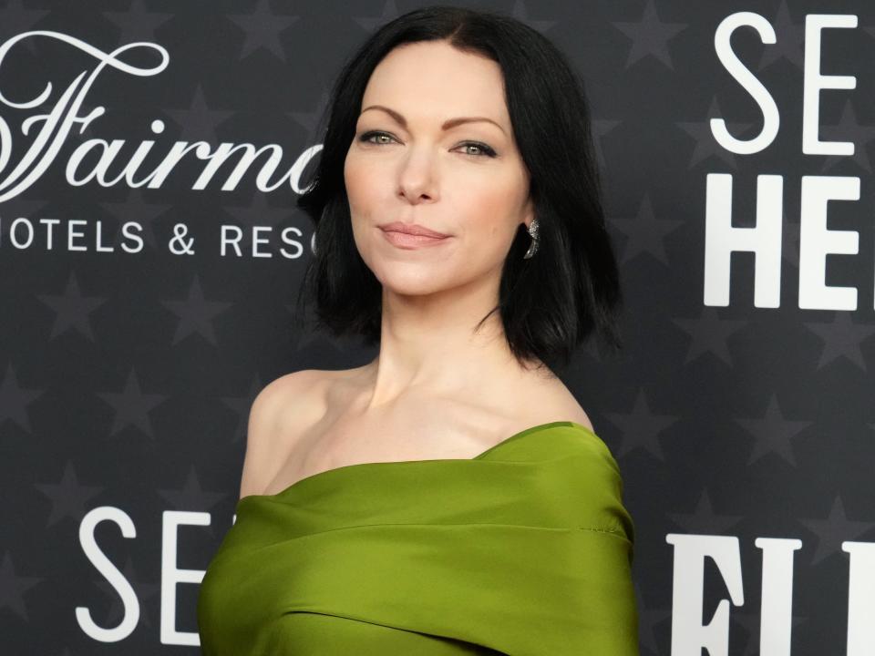 Actress Laura Prepon wearing a green off-the-shoulder dress in January 2023.