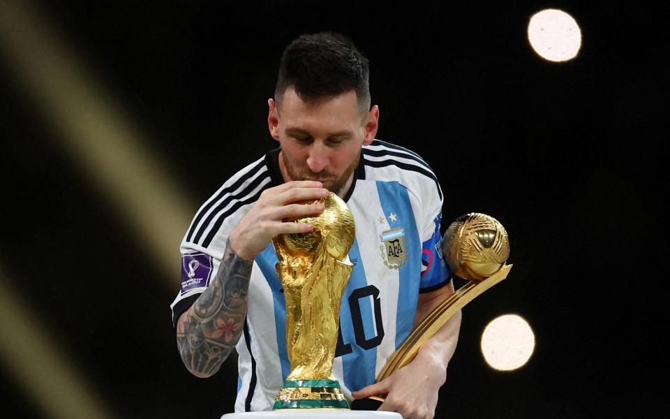 Argentina's Lionel Messi kisses the World Cup trophy after receiving the Golden Ball award as he celebrates after winning the World Cup - December 18, 2022 - KAI PFAFFENBACH/REUTERS