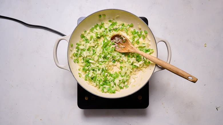 wooden spoon stirring garlic in a skillet