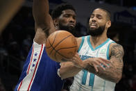 Charlotte Hornets forward Cody Martin passes around Philadelphia 76ers center Joel Embiid during the first half of an NBA basketball game on Monday, Dec. 6, 2021, in Charlotte, N.C. (AP Photo/Chris Carlson)