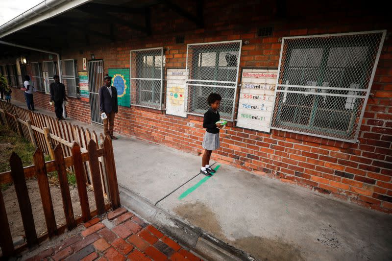 Learners observe social distancing markers as they queue at a school feeding scheme in Gugulethu township during a nationwide lockdown aimed at limiting the spread of coronavirus disease (COVID-19) in Cape Town