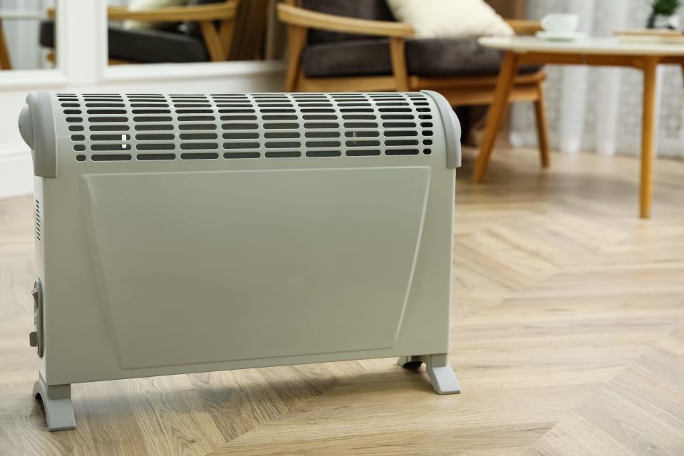 Modern electric convection heater on floor at home
