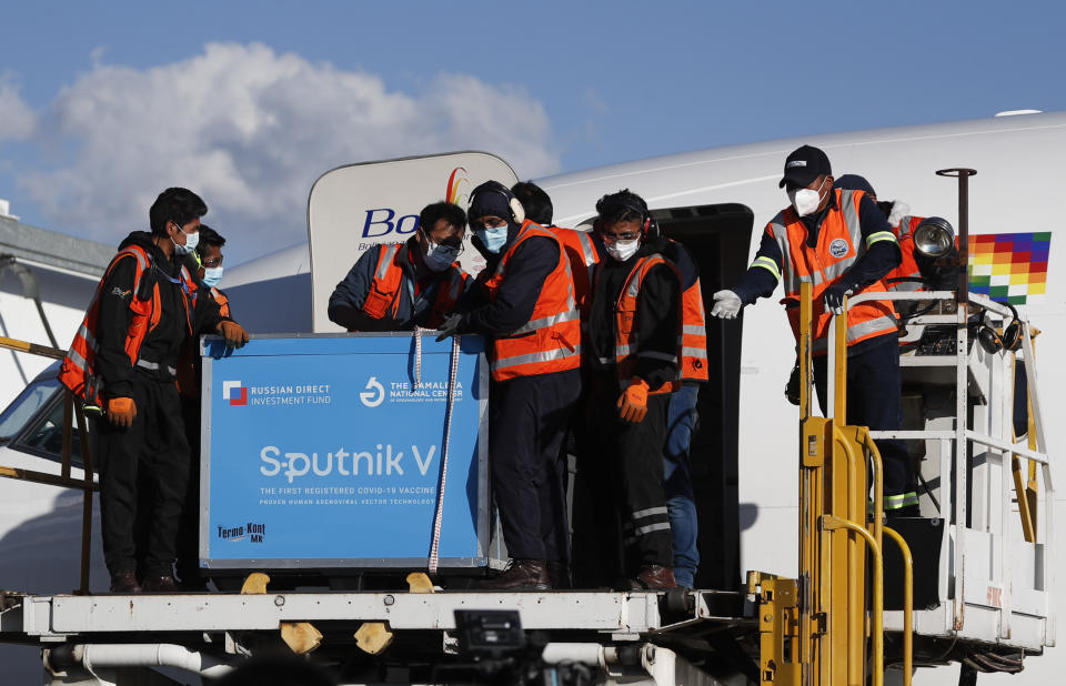 Los empleados del aeropuerto descargan el primer envío de la vacuna rusa Sputnik V contra COVID-19 después de que arribó al aeropuerto internacional de El Alto, en Bolivia, el jueves 28 de enero de 2021. (AP Foto/Juan Karita)