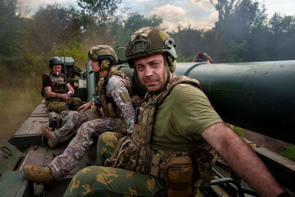 Ukrainian soldiers of 43rd artillery brigade ride atop on 2s7 self-propelled howitzer before firing towards Russian positions at the frontline in Donetsk region (AP)