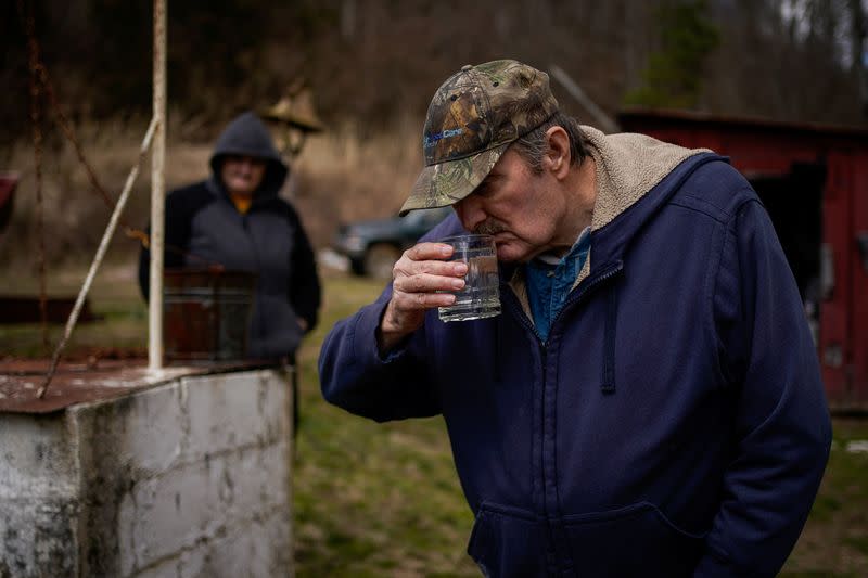 Hanson Rowe, a landowner who blames a leaky gas well on his property for health problems, smells water drawn from a contaminated well on his property in Salyersville