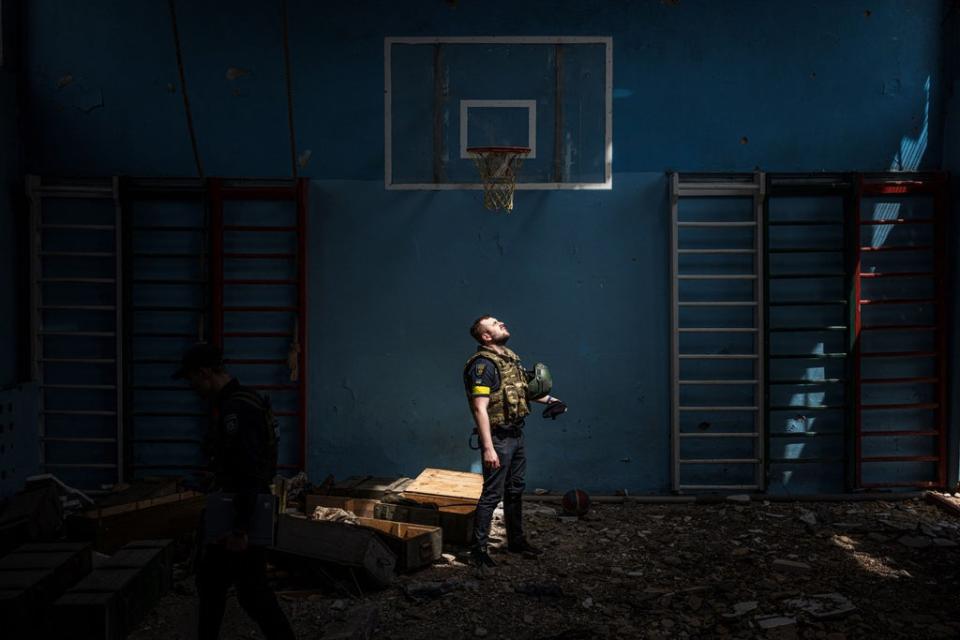 Un policía ucraniano parado afuera del gimnasio de una escuela afectada en Vilkhivka (AFP/Getty)