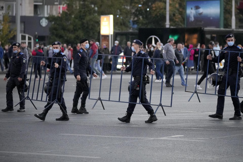 Riot police set up fences during an anti-government and anti-restrictions protest organised by the far-right Alliance for the Unity of Romanians or AUR, in Bucharest, Romania, Saturday, Oct. 2, 2021. Thousands took to the streets calling for the government's resignation, as Romania reported 12.590 new COVID-19 infections in the past 24 hour interval, the highest ever daily number since the start of the pandemic. (AP Photo/Vadim Ghirda)