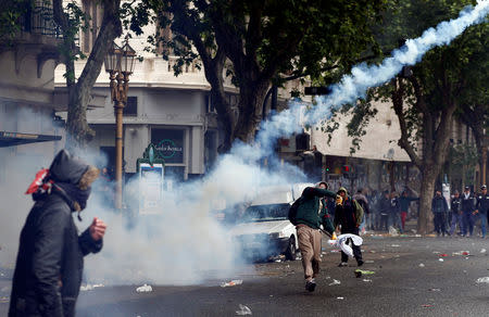 A protester throws back a tear gas canister at the police during clashes outside the Congress, where the budget bill is being debated, in Buenos Aires, Argentina October 24, 2018. REUTERS/Martin Acosta