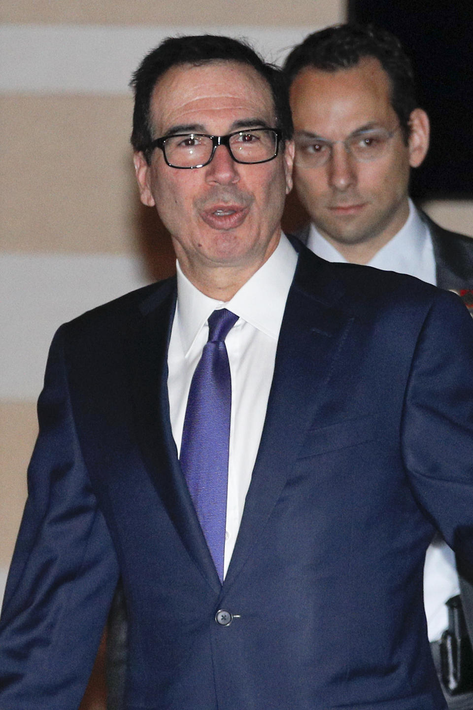 U.S. Treasury Secretary Steven Mnuchin speaks to journalists as he leaves a hotel to attend a new round of high-level trade talks with Chinese officials in Beijing, Thursday, Feb. 14, 2019. (AP Photo/Andy Wong)