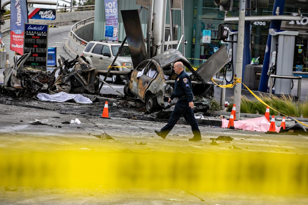 A law enforcement official walks by the scene of a deadly car crash.