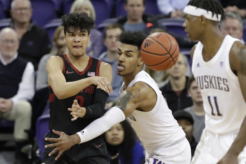 Stanford's Tyrell Terry, left, throws a pass past Washington's Jamal Bey during the second half of an NCAA college basketball game Thursday, Feb. 20, 2020, in Seattle. Stanford won 72-64. (AP Photo/Elaine Thompson)