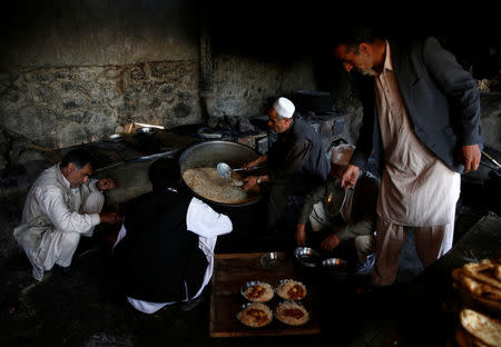 A cook (C) prepares lunch to be distributed to workers at the Jabal Saraj cement factory in Jabal Saraj, north of Kabul, Afghanistan May 8, 2016. REUTERS/Ahmad Masood