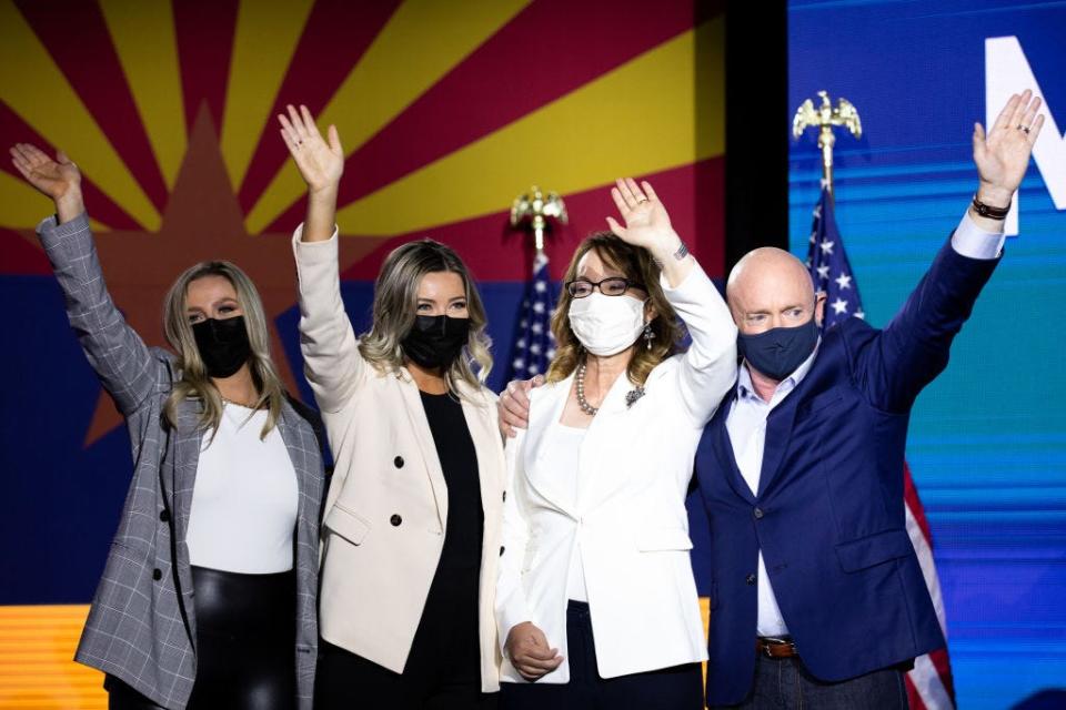 Mark Kelly, Gabrielle Giffords, and their children, Claudia and Claire wave to supporters on election night.