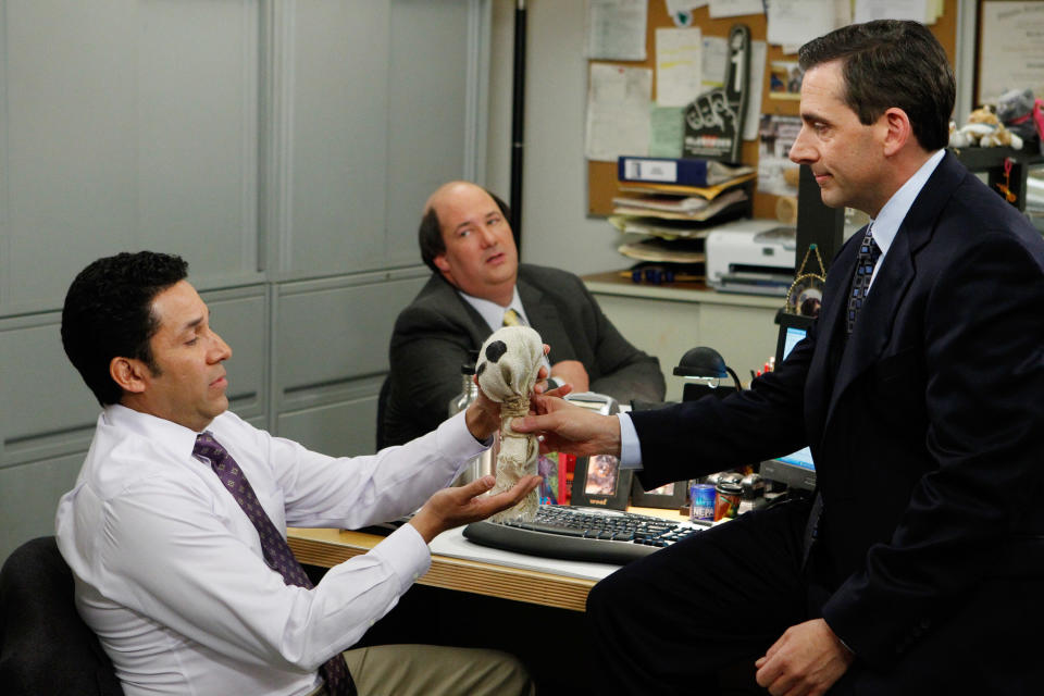 Michael Scott (Steve Carell) gives Oscar (Oscar Nunez) a farewell present in Carell's final episode of 'The Office,' which aired 10 years ago. (Photo: Chris Haston / © NBC / Courtesy: Everett Collection)