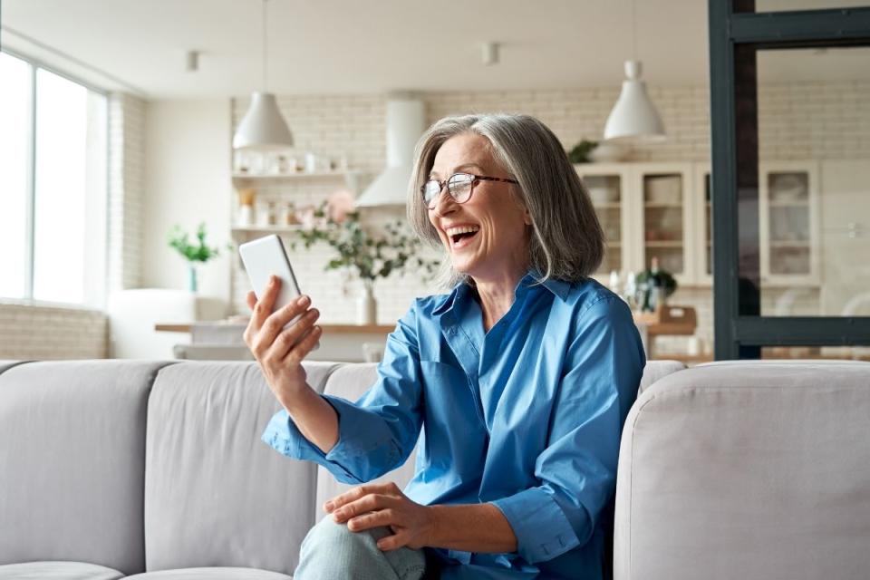 Woman looks excitedly at her phone. Source: Getty Images