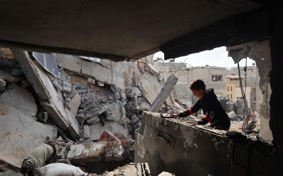 Palestinians inspect the damage following Israeli bombardment of Rafah's Tal al-Sultan district in the southern Gaza Strip on May 7, 2024.
