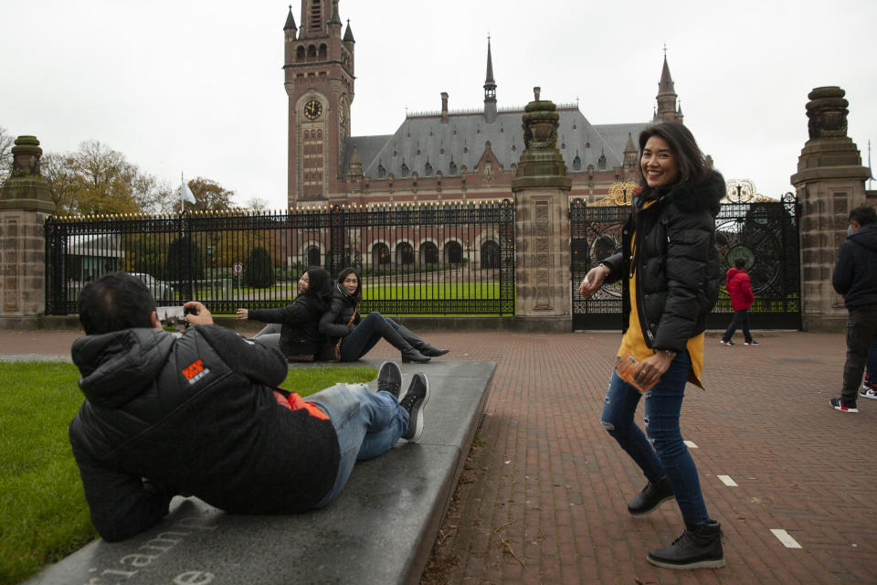 Tourists take pictures of the Peace Palace, rear, which houses the International Court in The Hague, Netherlands, Monday, Nov. 11, 2019, where Gambia filed a case at the United Nations' highest court accusing Myanmar of genocide in its campaign against the Rohingya Muslim minority. A statement released Monday by lawyers for Gambia says the case also asks the International Court of Justice to order measures "to stop Myanmar's genocidal conduct immediately." (AP Photo/Peter Dejong)
