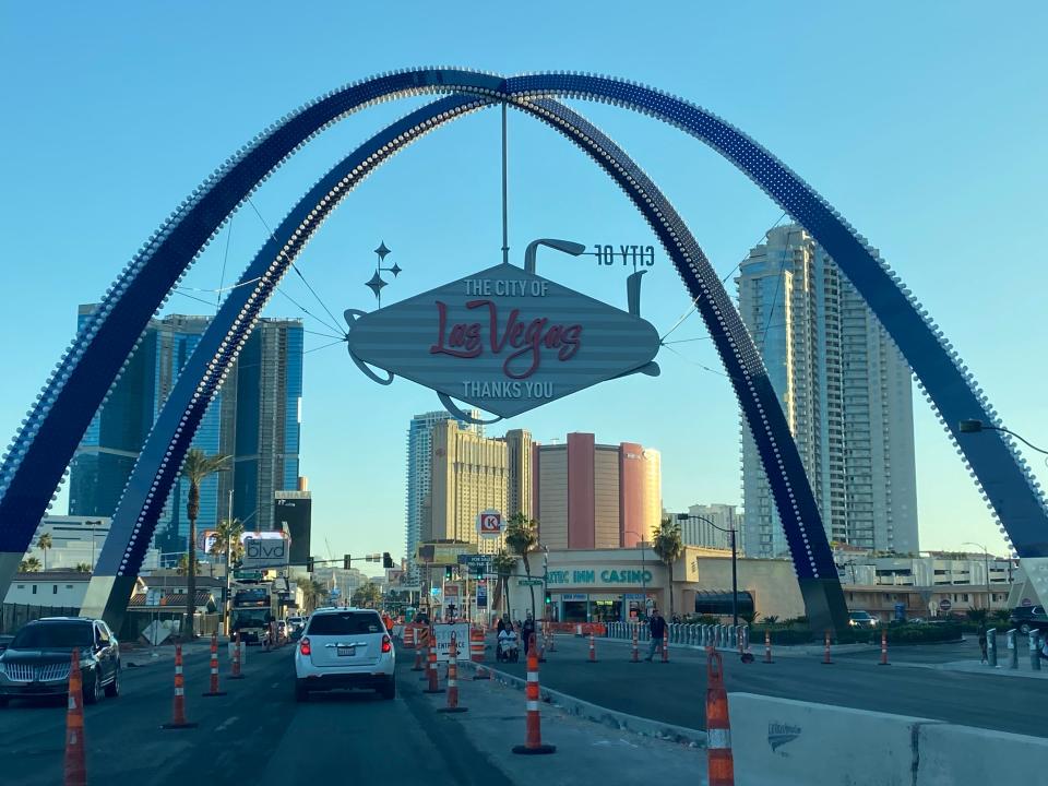 A Las Vegas banner hanging above a road with construction work being done on several lanes.