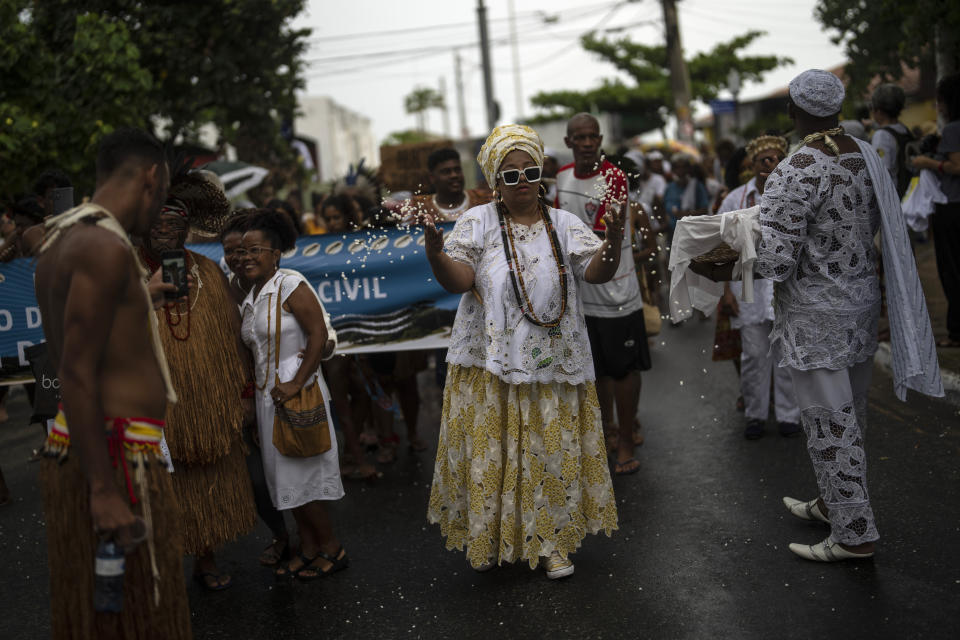 Una mujer tira palomitas de maíz durante un ritual candomblé de limpieza espiritual en Salvador (Brasil) el 18 de septiembre del 2022. (AP Photo/Rodrigo Abd)