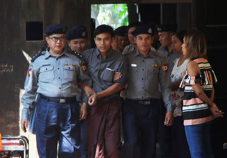 Detained Reuters journalist Kyaw Soe Oo is escorted by police as he arrives at a court hearing in Yangon, Myanmar March 14, 2018. REUTERS/Stringer