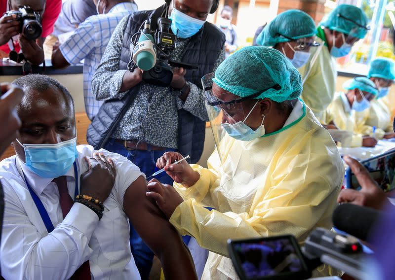 FILE PHOTO: A health worker vaccinates a man against the coronavirus disease (COVID-19), in Harare