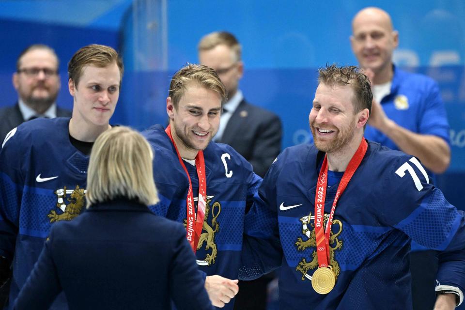 Finland's Valtteri Filppula (C) and Leo Komarov pose with their gold medals after the men's gold medal match of the Beijing 2022 Winter Olympic Games ice hockey competition between Finland and Russia's Olympic Committee, at the National Indoor Stadium in Beijing on Feb. 20, 2022.