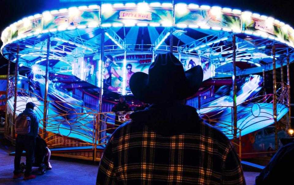 Marcelo Aguilar watches his daughter ride on the ‘Big Kahuna’ ride in the carnival midway area of the Fort Worth Stock Show and Rodeo.