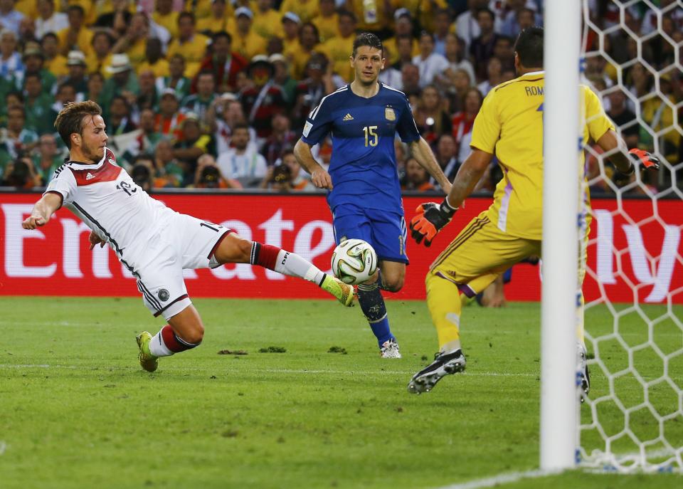 Germany's Mario Goetze shoots to score a goal past Argentina's goalkeeper Sergio Romero during extra time in their 2014 World Cup final at the Maracana stadium in Rio de Janeiro July 13, 2014. REUTERS/Kai Pfaffenbach (BRAZIL - Tags: SOCCER SPORT WORLD CUP TPX IMAGES OF THE DAY) TOPCUP