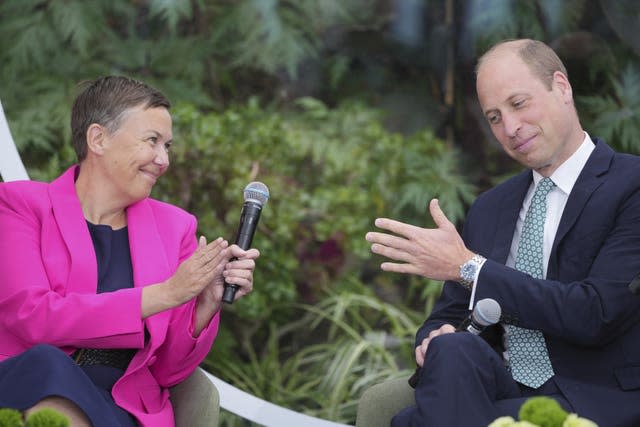 The Prince of Wales speaks to a woman in a pink jacket