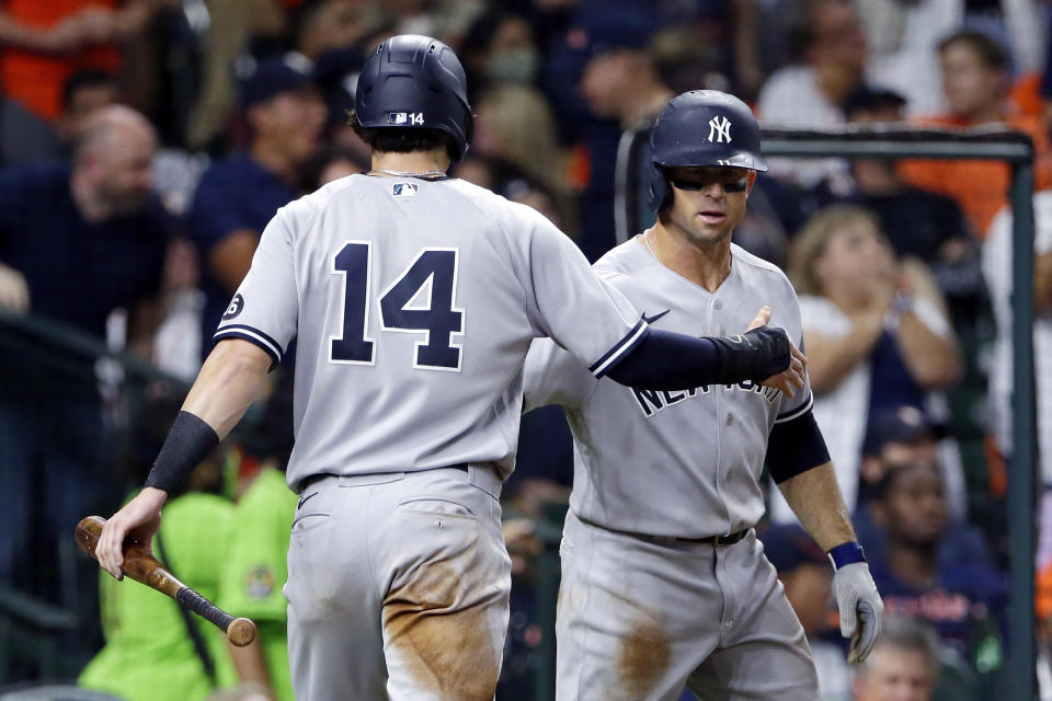 New York Yankees' Tyler Wade (14) and Brett Gardner, right, celebrate after both scored on a double by DJ LeMahieu during the seventh inning of the team's baseball game against the Houston Astros on Friday, July 9, 2021, in Houston. (AP Photo/Michael Wyke)