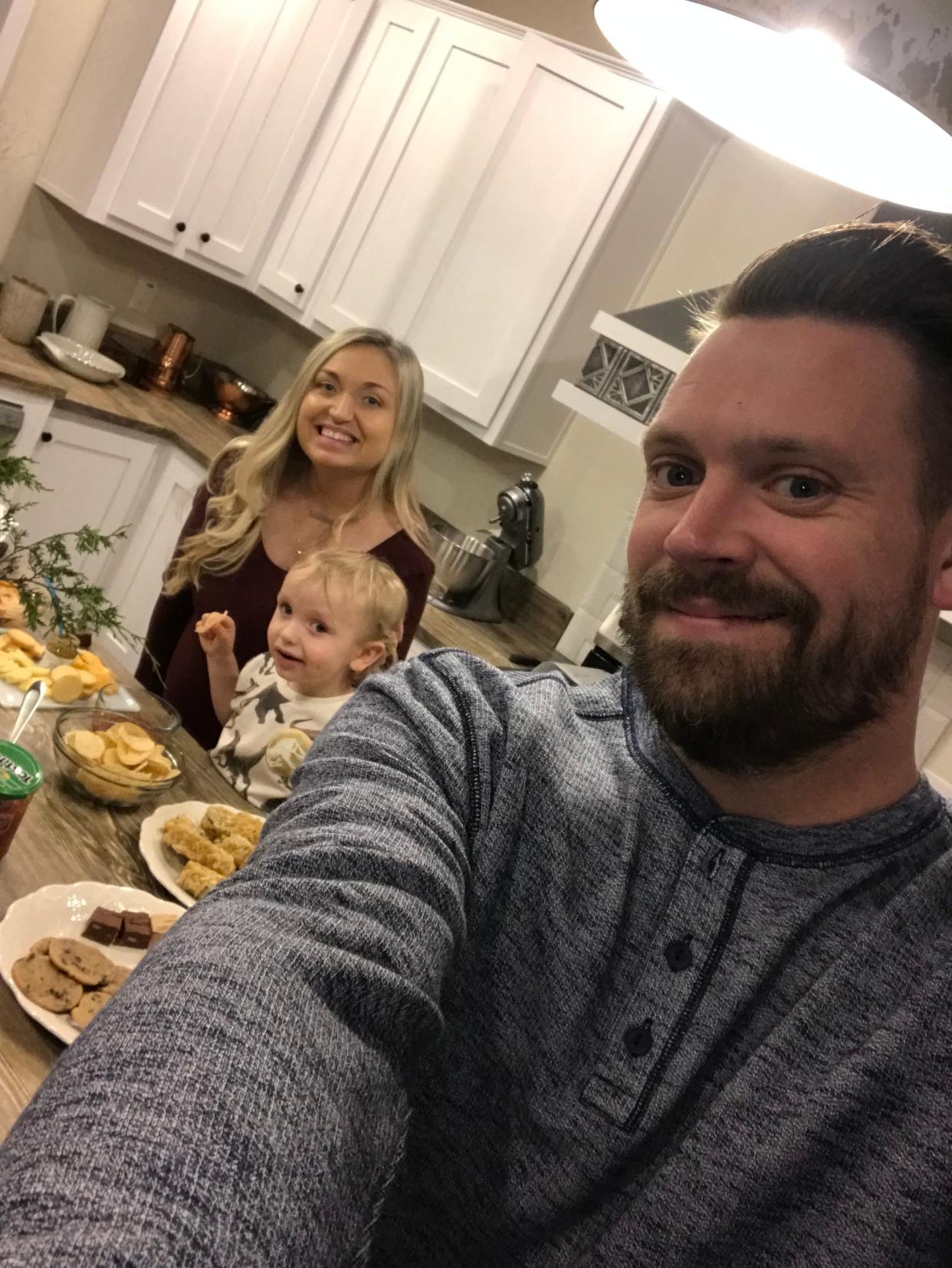 Chesney Cross, her husband, Ken and their child Cash in their new kitchen.