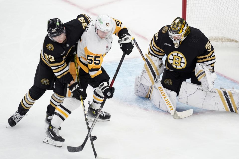 Boston Bruins' Morgan Geekie (39) and Pittsburgh Penguins' Noel Acciari (55) battle for the puck in front of Linus Ullmark (35) during the second period of an NHL hockey game, Saturday, March 9, 2024, in Boston. (AP Photo/Michael Dwyer)